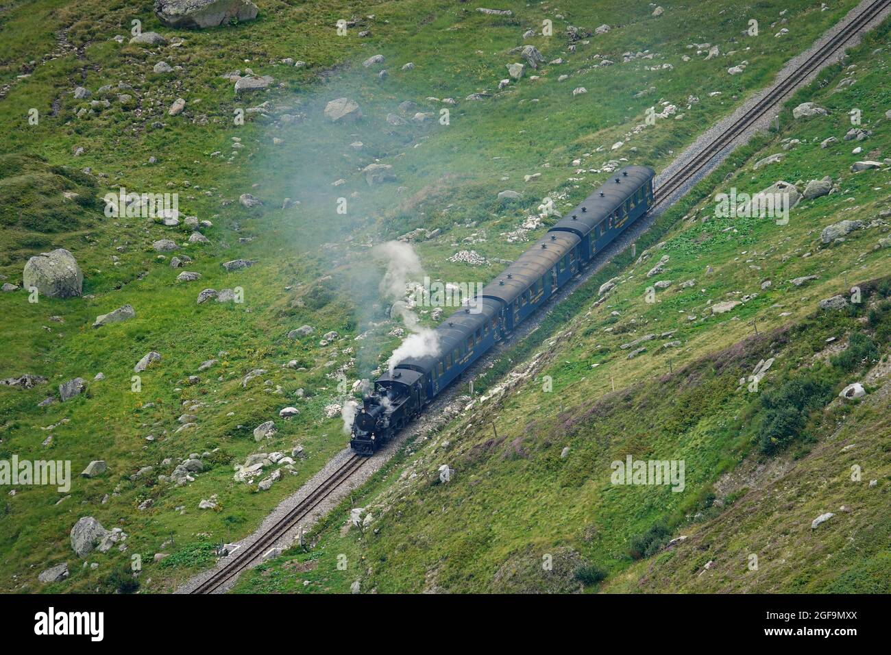 Furka-Dampfzug durch die Berglandschaften der Zentralalpen auf der historischen Glacier Express-Route. Furkapass, Schweiz - August 2021 Stockfoto