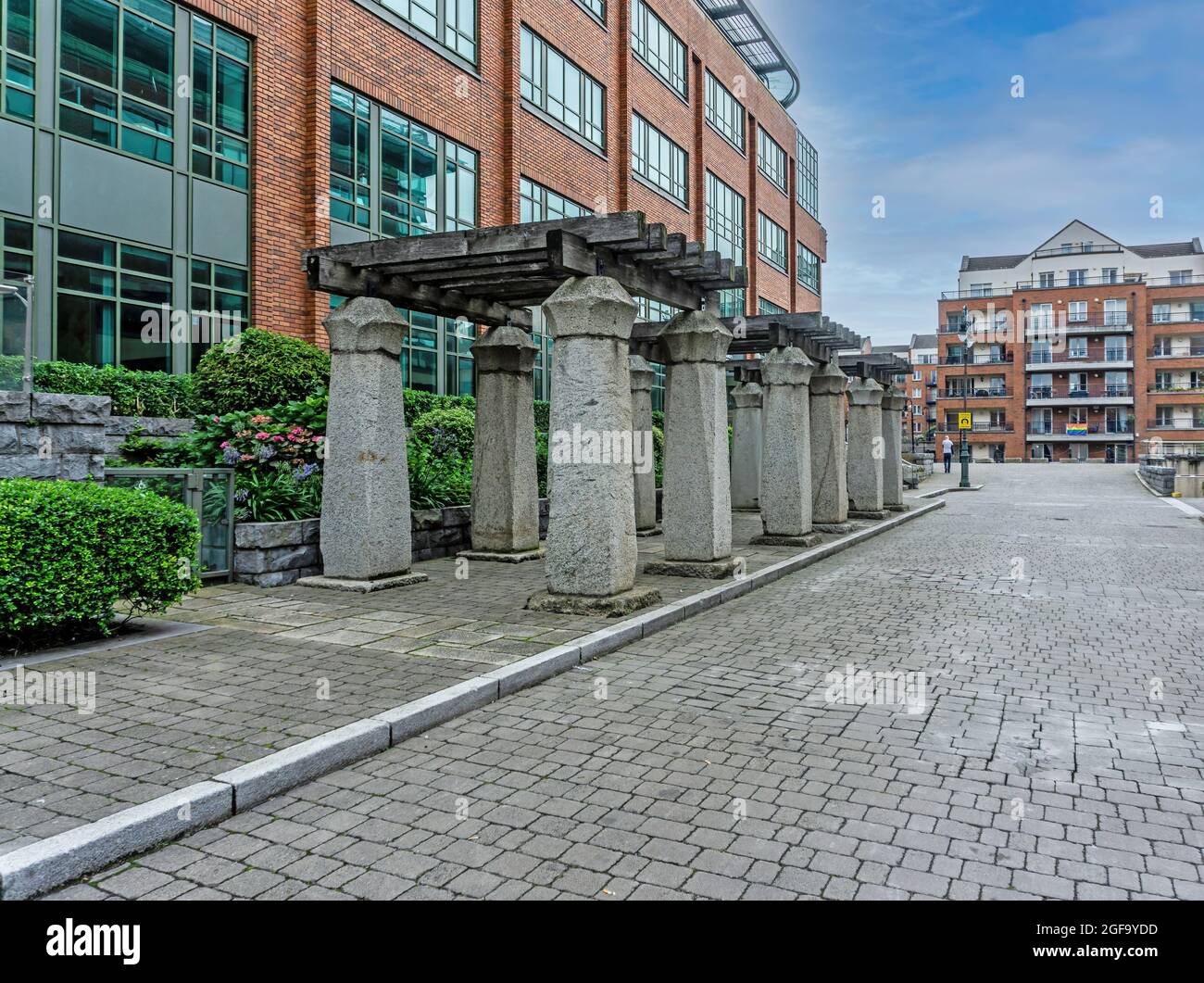 12 Steinsäulen vor 3 Georges Dock, einem Bürogebäude, in den Docklands von Dublin, Irland. Stockfoto