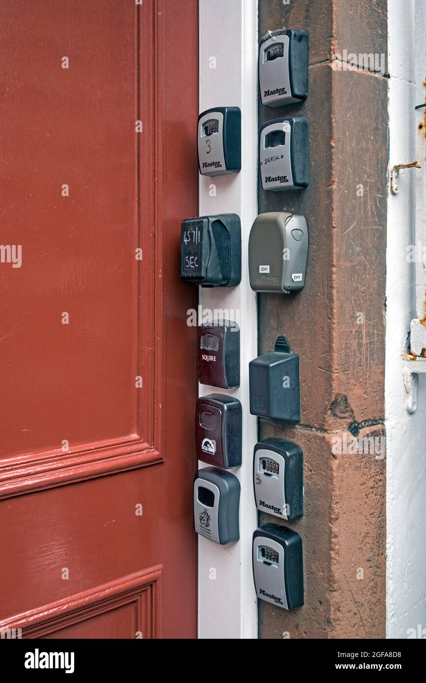 Elf Schlüsseltresore für kurzfristige oder Airbnb-Zimmer am Eingang zu einem Mietshaus im Lawnmarket in der Altstadt von Edinburgh. Stockfoto