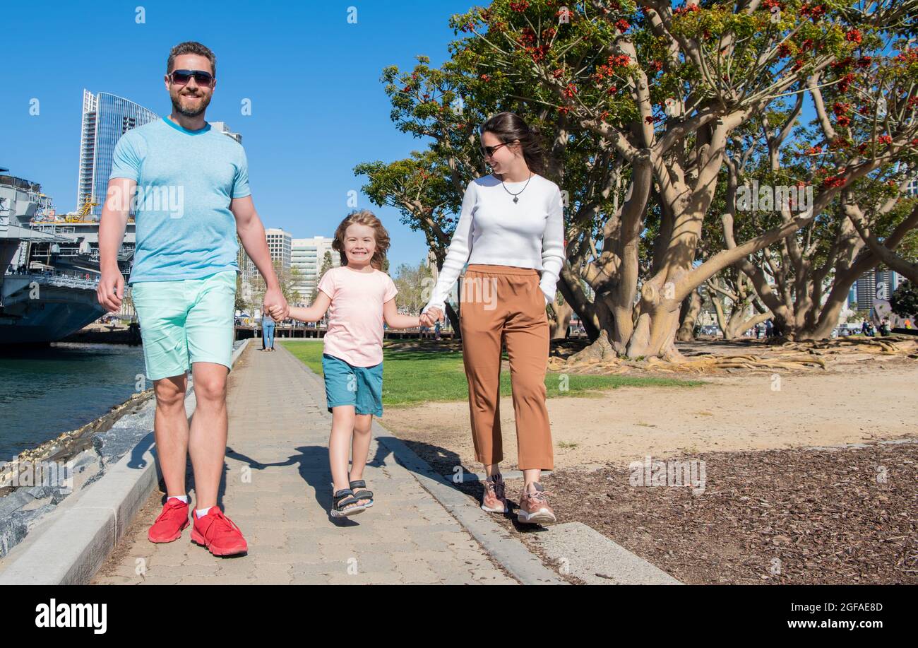 Glückliche junge Familie, die im Park mit Sohn, Familie läuft Stockfoto