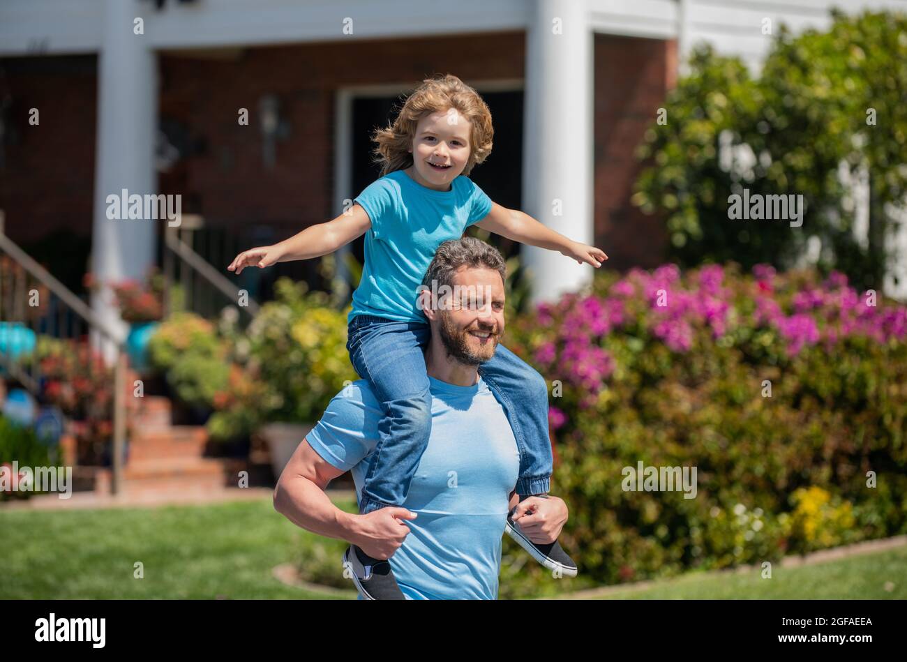 Glücklicher Vater mit Sohn entspannen sich zusammen neben dem Haus, europäische Familie Stockfoto