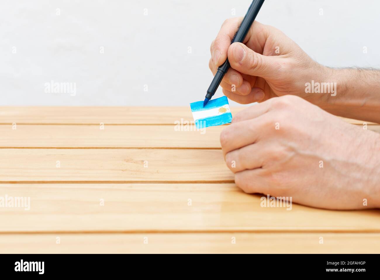 Mann, der eine argentinische Flagge mit einer hellblauen Faser schmückt Stockfoto