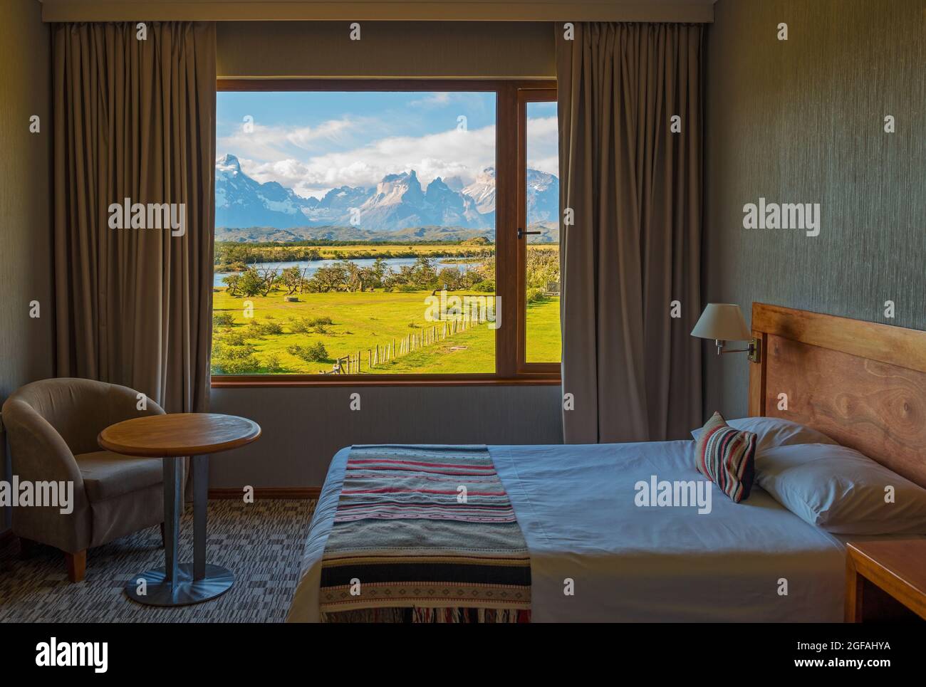 Hotelzimmer mit klassischem Design und offenen Vorhängen mit Blick auf den Cuernos del Paine, den Nationalpark Torres del Paine, Patagonien, Chile. Stockfoto