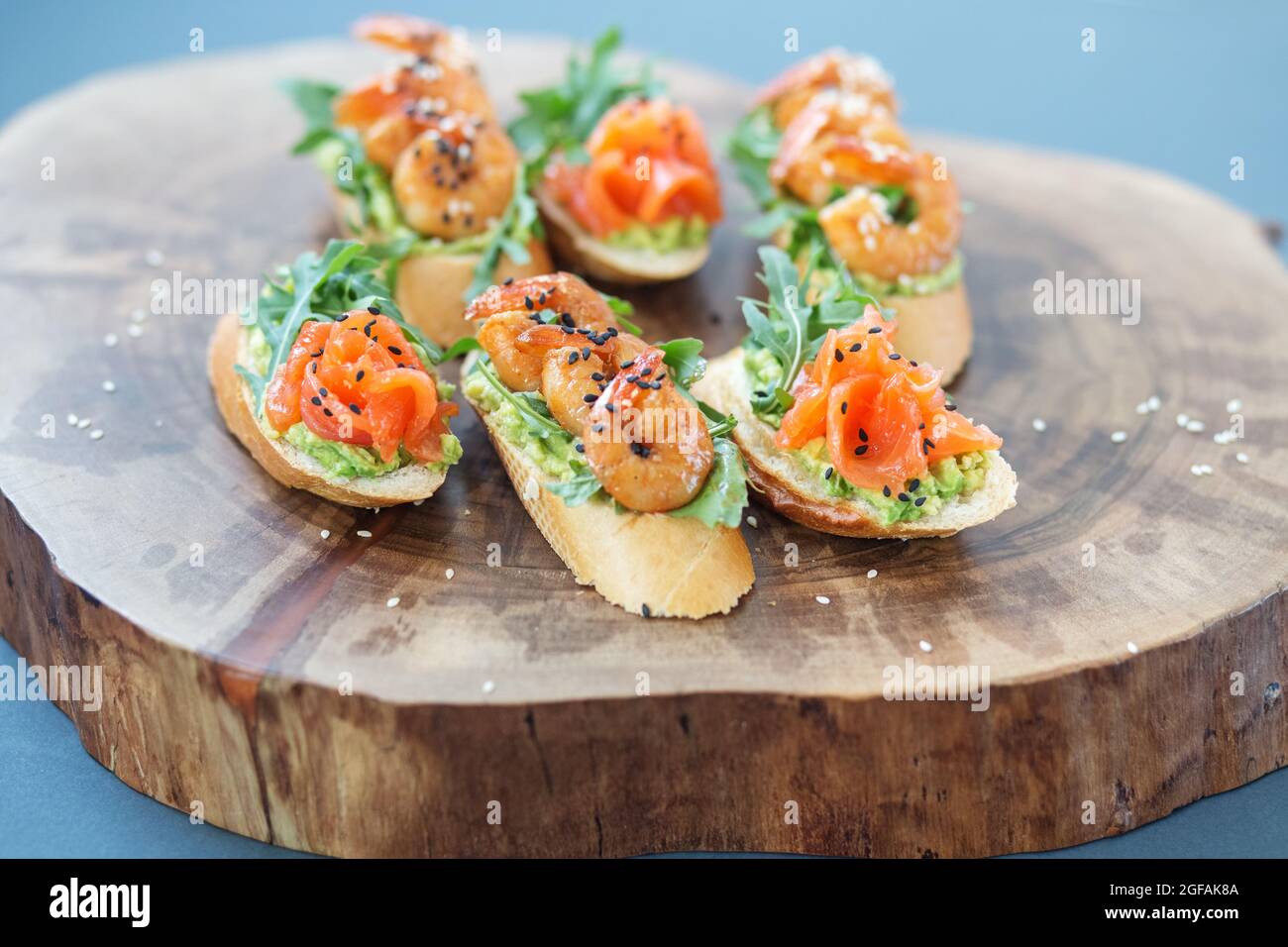 Bruschetta mit Avocado und Lachs, Shrimp Sandwich auf einem Buffetteller auf einem Holzständer Stockfoto