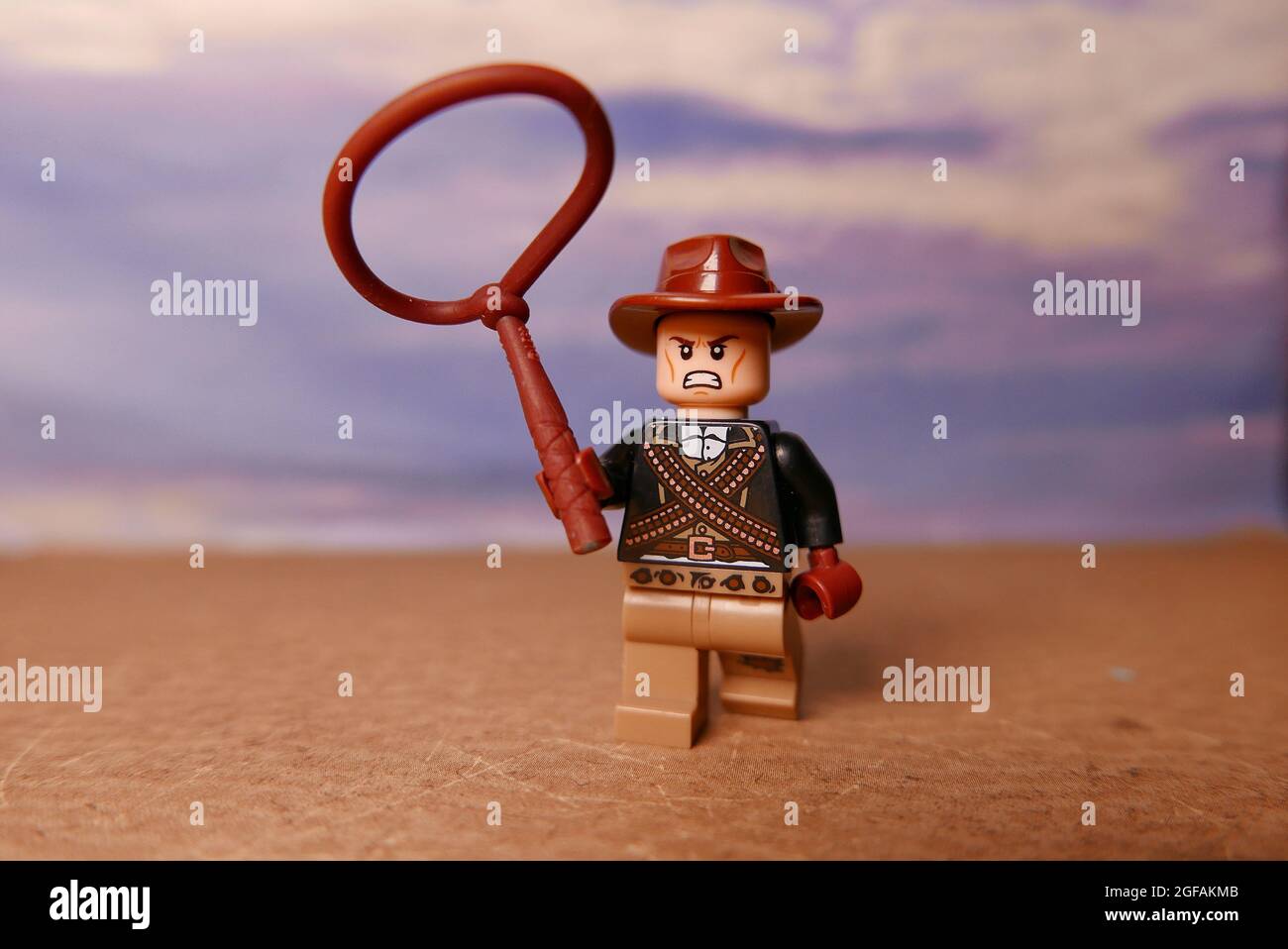 GREENVILLE, USA - 31. Jul 2021: Nahaufnahme einer wütenden Cowboy-Figur von Lego, die ein Lasso auf blauem Hintergrund wirft Stockfoto