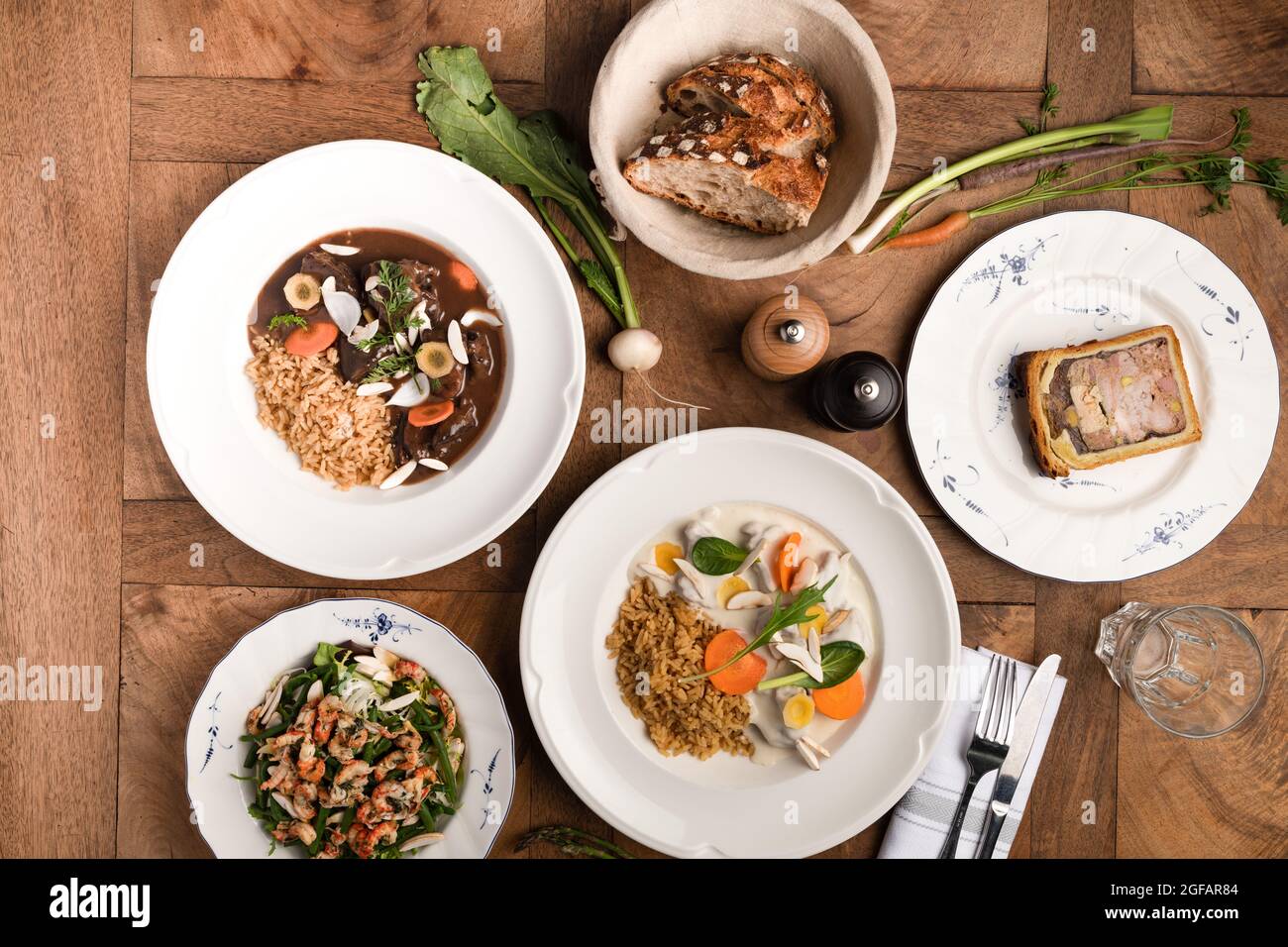Französisch und schmeckte Speisen auf Tellern auf dem hölzernen und traditionellen Tisch Stockfoto