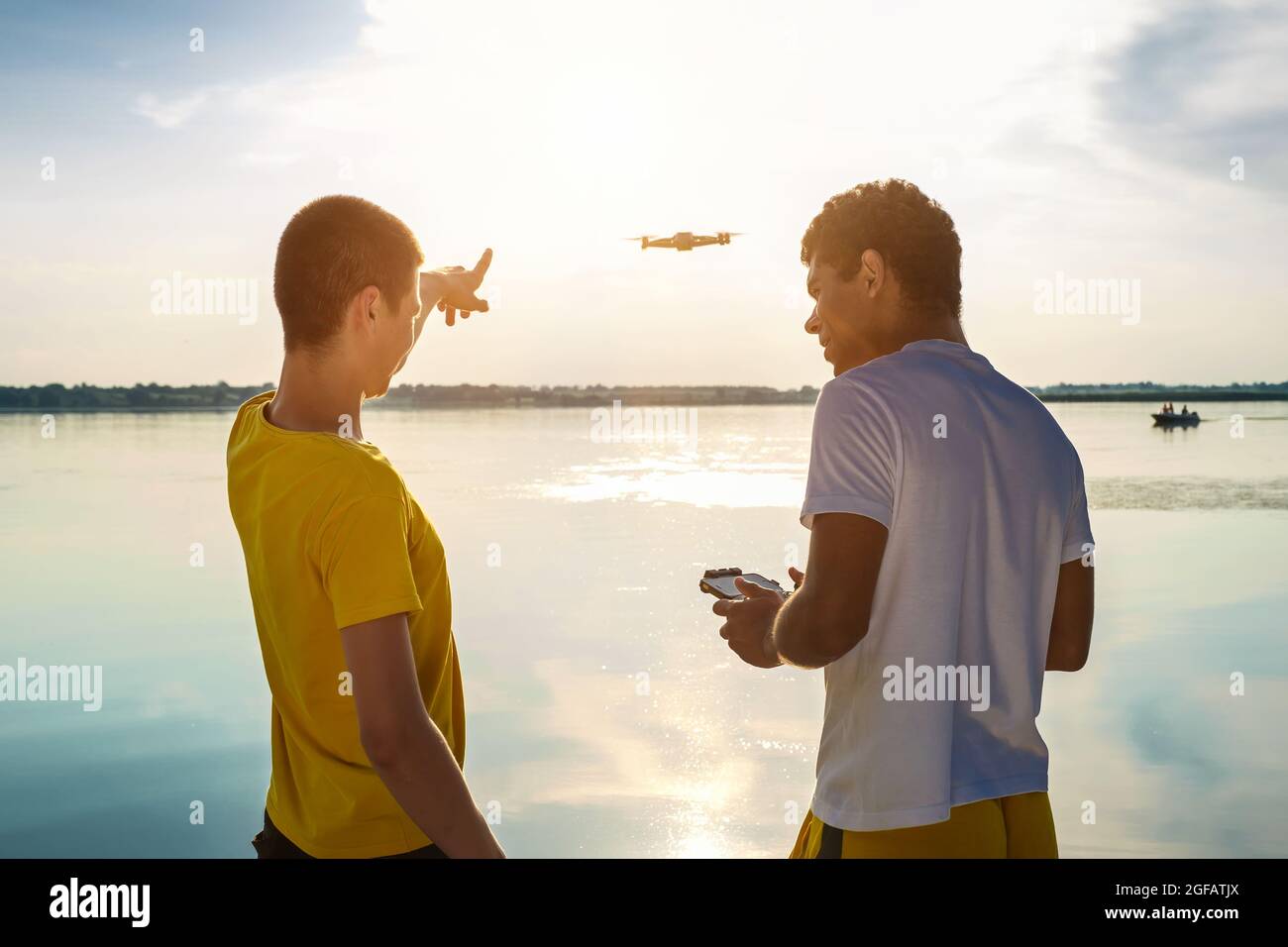 Zwei Freunde operieren Drohne mit Controller in der Nähe des Flusses stehen Stockfoto