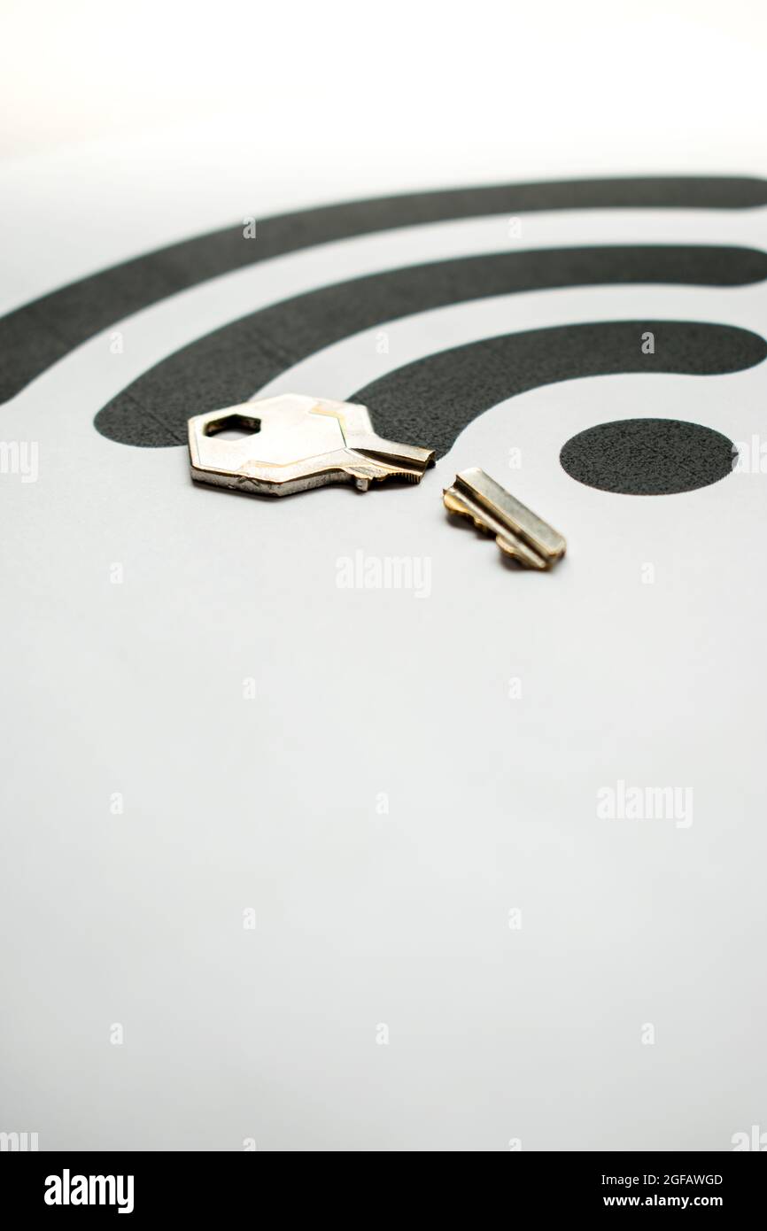 Zerbrochener Schlüssel aus Metall auf weißem Hintergrund mit einem großen schwarzen WiFi-Symbol mit Kopierbereich Stockfoto