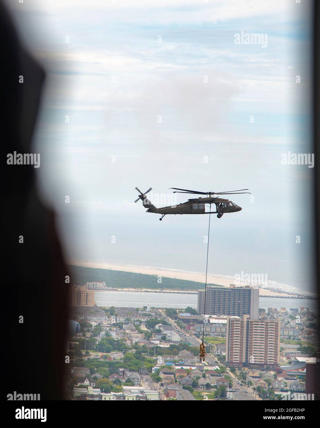 Mitglieder des 227. Air Support Operations Squadron, vom 177. Fighter Wing der New Jersey Air Natoional Guard, Und eine New Jersey Army National Guard UH-60 Black Hawk Helikopter-Crew führt eine Demonstration von Special Patrol Insertion and Exfiltration (SPIONE) und Fast Rope Infiltration and Extraction (FRIES) am 18. August 2021 über dem Atlantik durch Atlantic City, N.J. durch Die Kundgebung VON SPIONEN und POMMES WAR eine von vielen Akten, die 2021 auf der Atlantic City Air Show „A Salute to Those Who Serve“ aufgeführt wurden. (USA Foto der Air National Guard von Senior Airman Hunter Hires) Stockfoto
