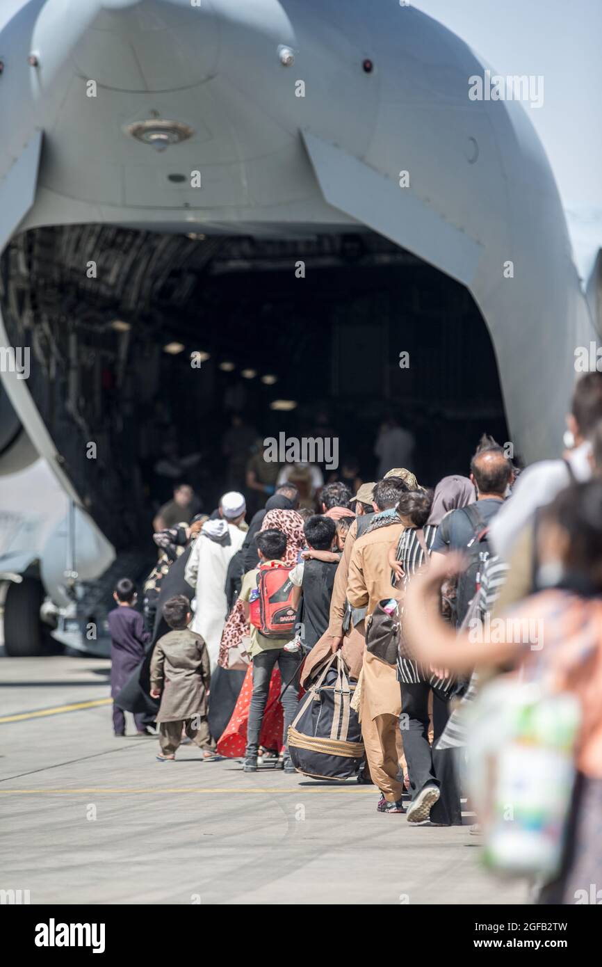 Familien besteigen eine Boeing C-17 Globemaster III der US-Luftwaffe während einer Evakuierung am Hamid Karzai International Airport, Kabul, Afghanistan, 24. August. US-Dienstmitglieder unterstützen das Außenministerium bei einer geordneten Abseichung von designiertem Personal in Afghanistan. (USA Marine Corps Foto von Sgt. Samuel Ruiz). Stockfoto