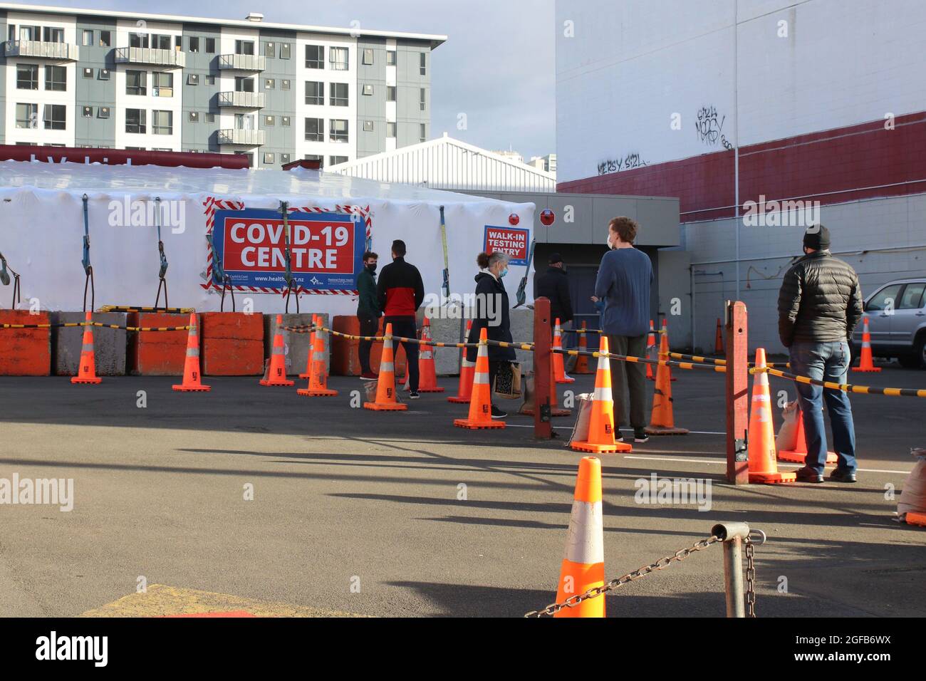 Wellington, Neuseeland, 25. August 2021. Am frühen Morgen stehen Menschen in einem Testzentrum in Wellington, Neuseeland, an, das aufgrund eines Ausbruchs der Delta-Variante derzeit in einer strikten Stufe-4-Sperre ist. Quelle: Lynn Grieveson/Alamy Live News Stockfoto