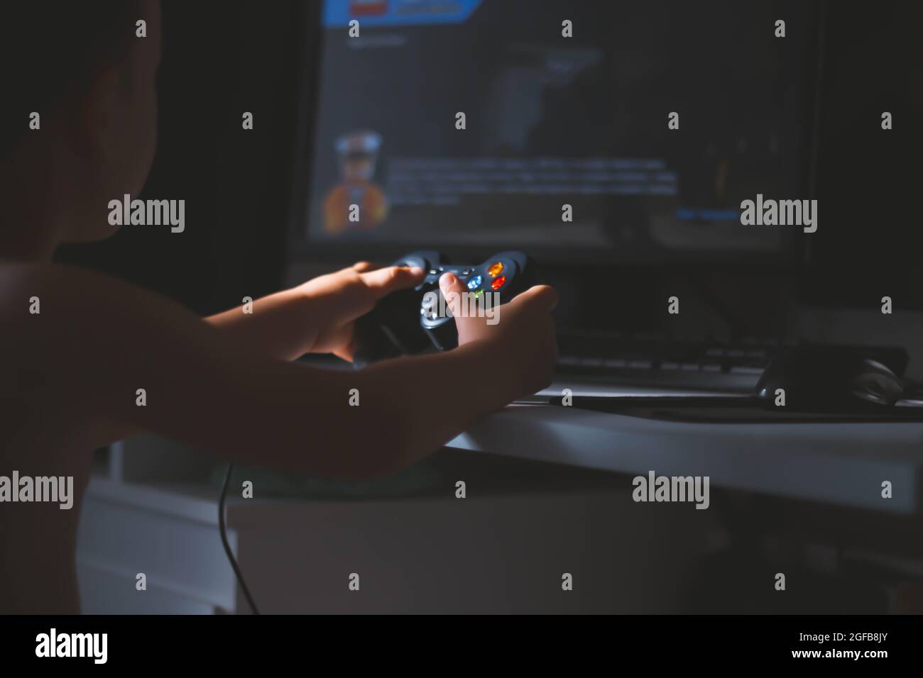 Der Junge spielt ein Computerspiel. Joystick in der Hand. Ein Spieler in einem Computerclub. Spiele für Kinder. Stockfoto