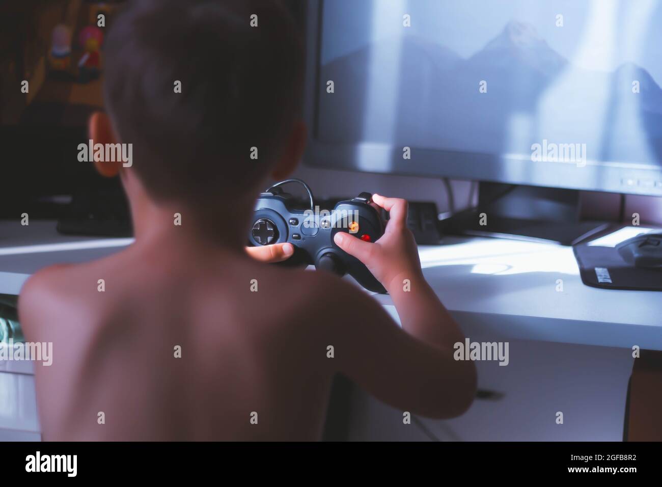 Der Junge spielt ein Computerspiel. Joystick in der Hand. Ein Spieler in einem Computerclub. Spiele für Kinder. Stockfoto