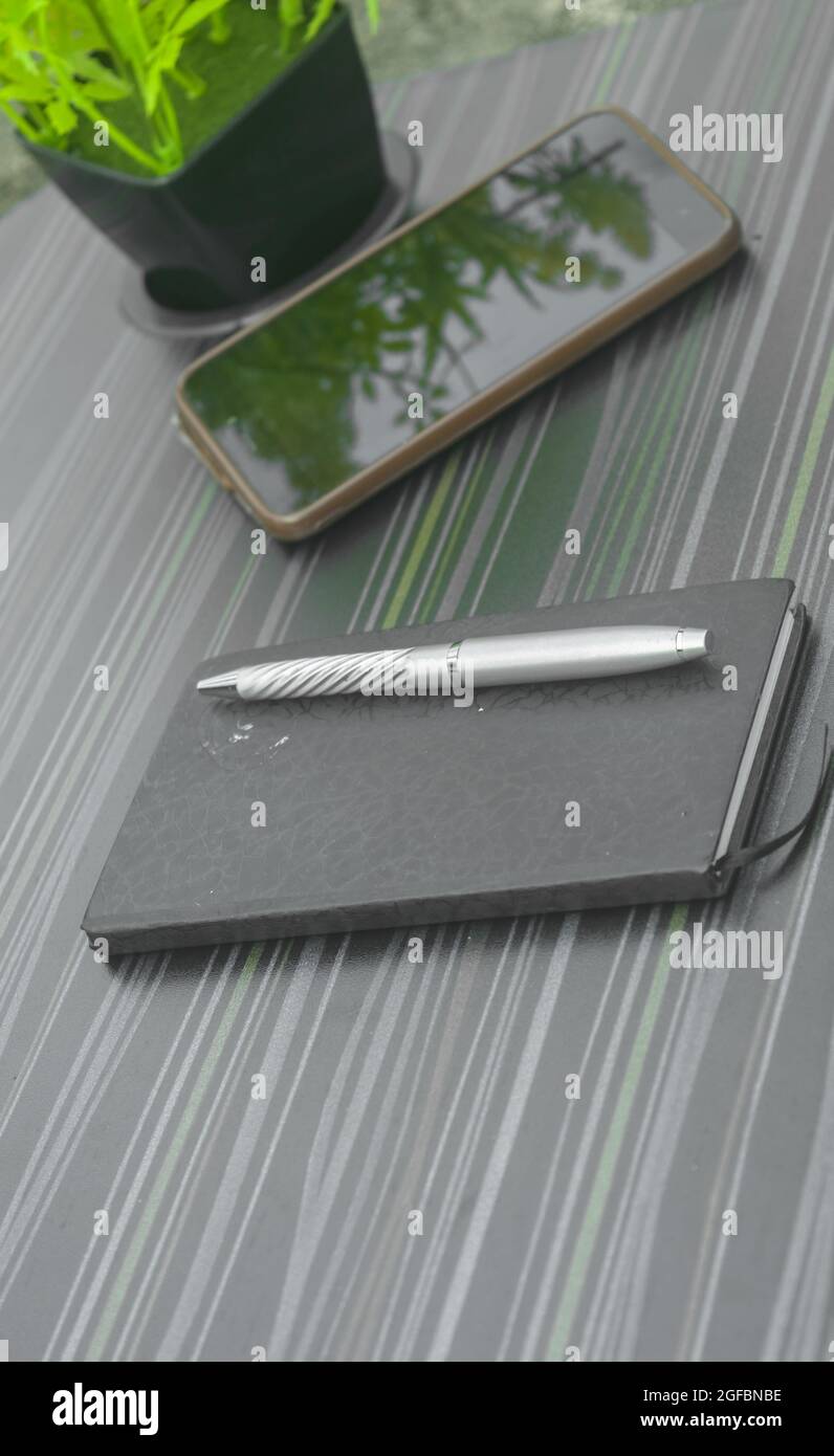 Stift und Notizbuch auf dem Bürotisch. Tabellenansicht von oben. Unternehmenshintergrund. Stockfoto