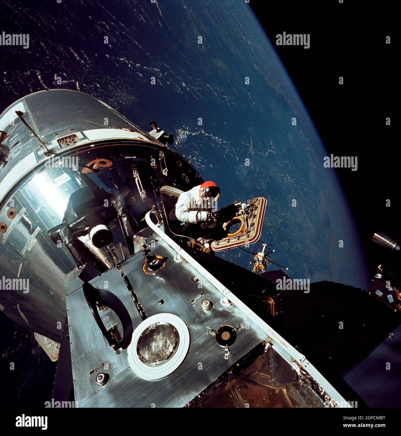 (6. März 1969) --- ausgezeichnete Sicht auf die angedockten Apollo 9 Command and Service Modules (CSM) und das Mondmodul (LM), mit der Erde im Hintergrund, während der Stand-up-Extravehicular-Aktivität (EVA) von Astronaut David R. Scott am vierten Tag der Apollo 9-Erdorbitalmission. Scott, Pilot des Befehlsmoduls, steht in der offenen Luke des Befehlsmoduls (CM) Stockfoto