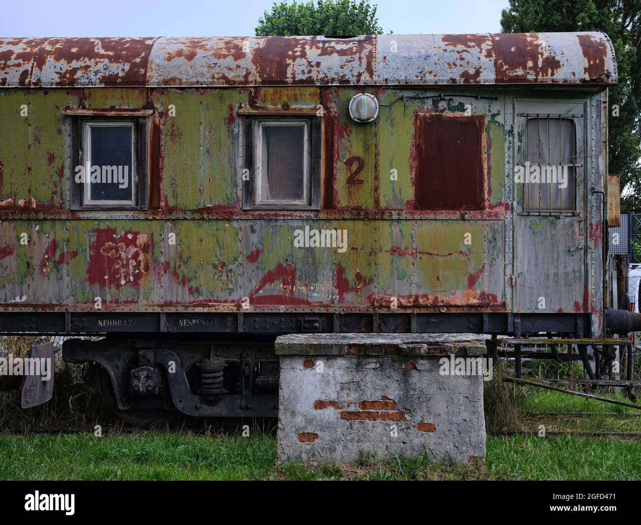 Verwitterter grüner Triebwagen mit abblätternder Farbe, Rost und alten Fenstern, die Eisenbahnerbe und industriellen Verfall zeigen. Stockfoto