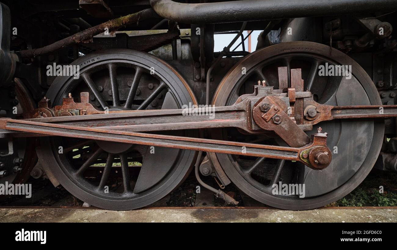 Nahaufnahme der Antriebsräder und Pleuelstangen von Dampflokomotiven, die alte Eisenbahntechnik und mechanische Details zeigen. Stockfoto