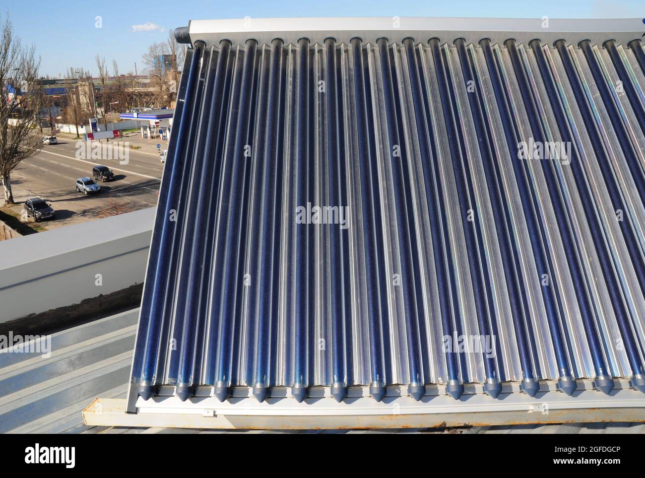 Ein evakuierter Rohrtechnologie Solar-Warmwassersammler auf dem Dach eines Wohnhauses installiert. Wirtschaftliches und energieeffizientes passives Solarwasser Stockfoto