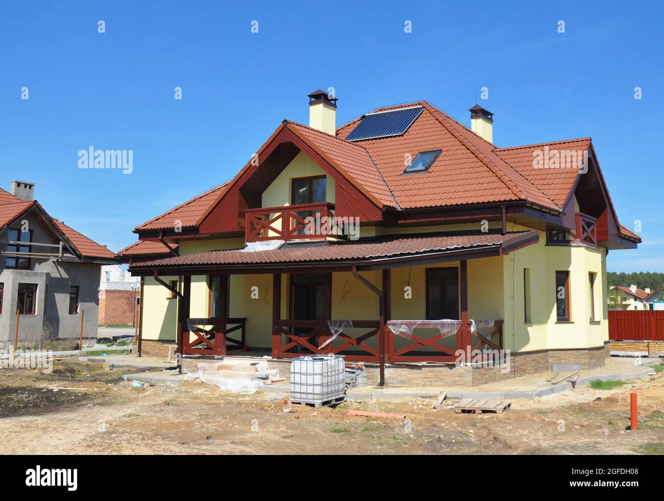 Der Bau eines energieeffizienten Hauses mit einem komplexen Kreuzgiebel Dach mit Blitzschutz und Tonfliesen, Blitzableiter, Terrasse, Stuck w Stockfoto