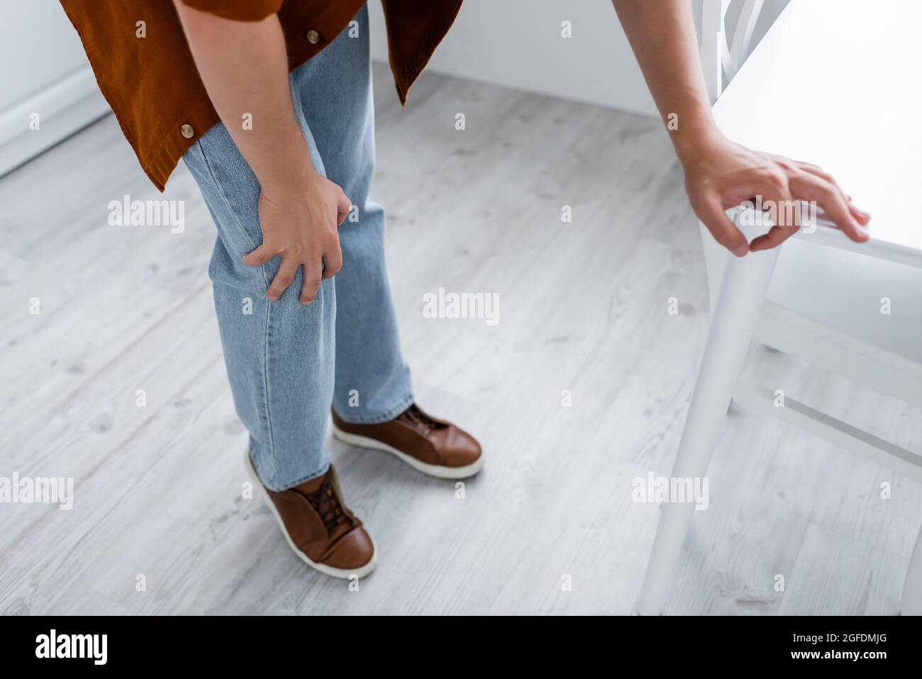 Beschnittene Ansicht des Mannes, der zu Hause an Knieschmerzen leidet Stockfoto