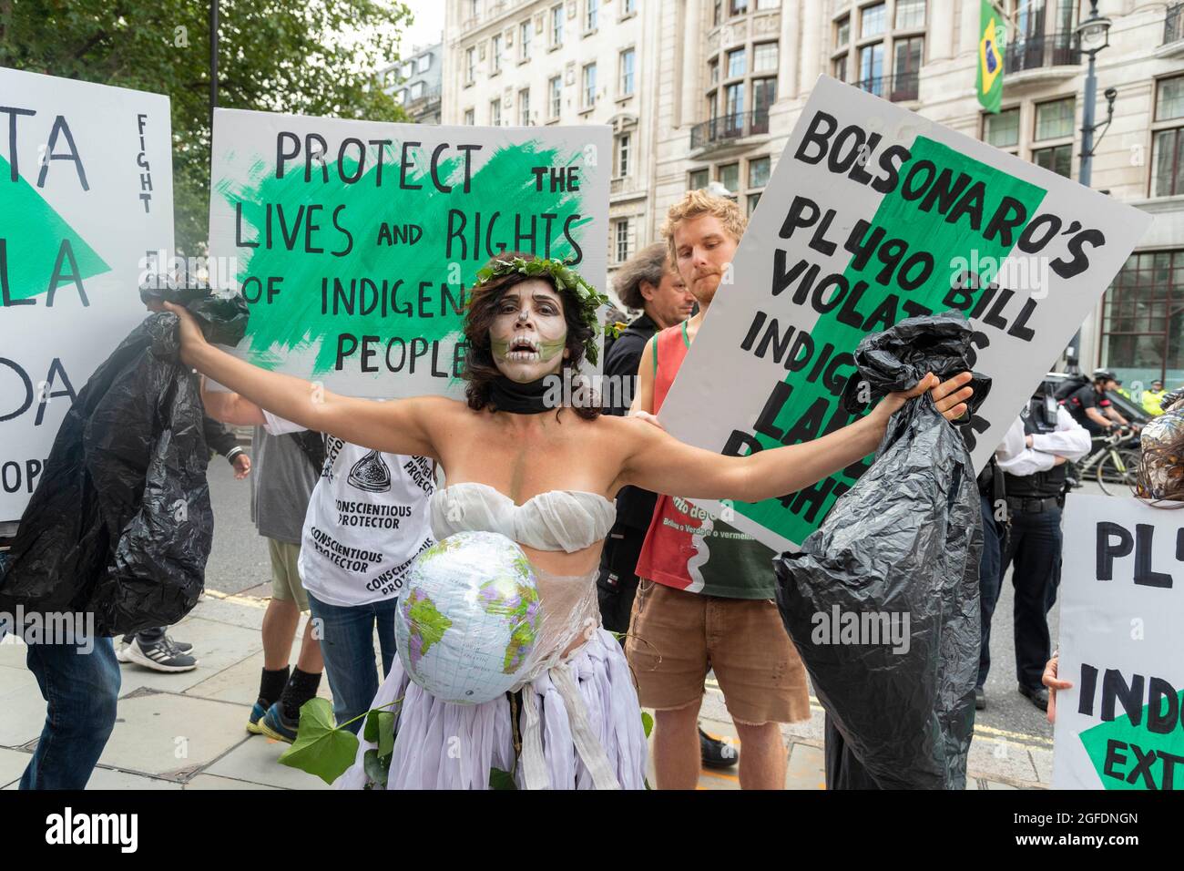 London, Großbritannien - am 25. August 2021 tritt EIN Protestler in Plastikkostümen bei einem Protest vor der brasilianischen Botschaft in London auf, der sich vor der brasilianischen Botschaft in London versammelten, um ein Ende der völkermordenden Angriffe gegen die indigenen Völker Brasiliens zu fordern. Unterstützer von Amazonasrebellion, Brazil Matters, CAFOD, Greenpeace, Parents for Future and Survival International protestieren im Rahmen der globalen Aktion „Struggle for Life“ („Luta pela Vida“) unter der Leitung der Vereinigung indigener Völker Brasiliens (APIB) gegen den brasilianischen Völkermord. Stockfoto