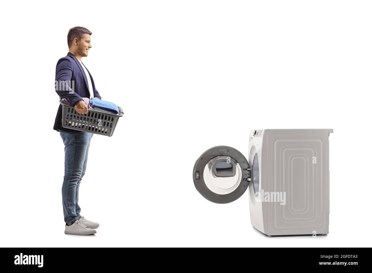 Ganzkörperaufnahme eines Mannes mit einem Wäschekorb, der vor einer Waschmaschine auf weißem Hintergrund isoliert steht Stockfoto Ganzkörperaufnahme eines Mannes mit einem Wäschekorb, der vor einer Waschmaschine auf weißem Hintergrund isoliert steht Stockfoto