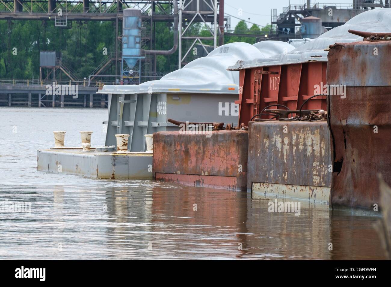 NEW ORLEANS, LA, USA - 29. MAI 2021: Lastkähne auf dem Mississippi River mit Getreideaufzug über den Fluss im Hintergrund Stockfoto