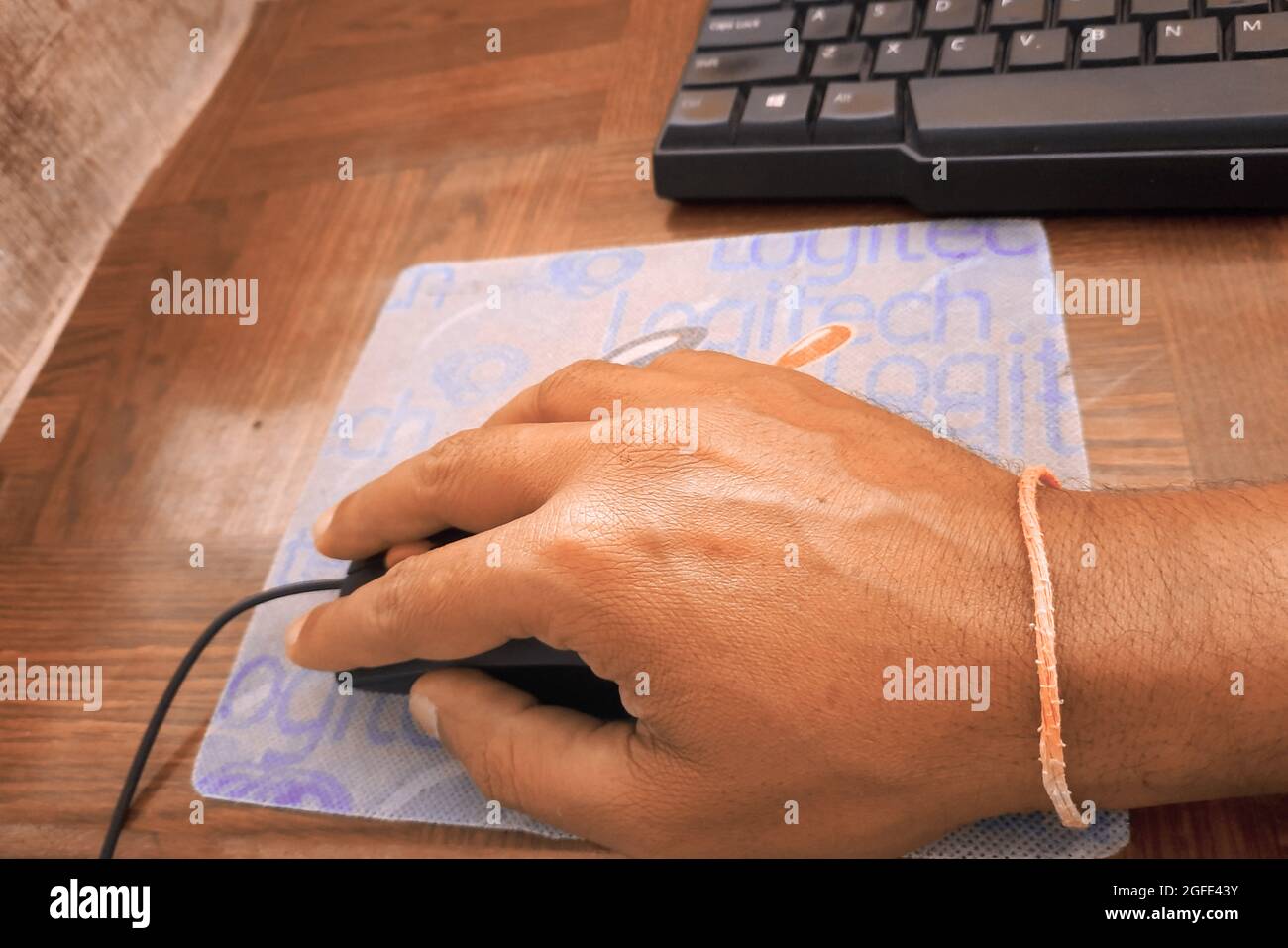 Bild einer weiblichen Hand-Klick-Computermaus. Eine Computertastatur ist in der Nähe platziert. Stockfoto