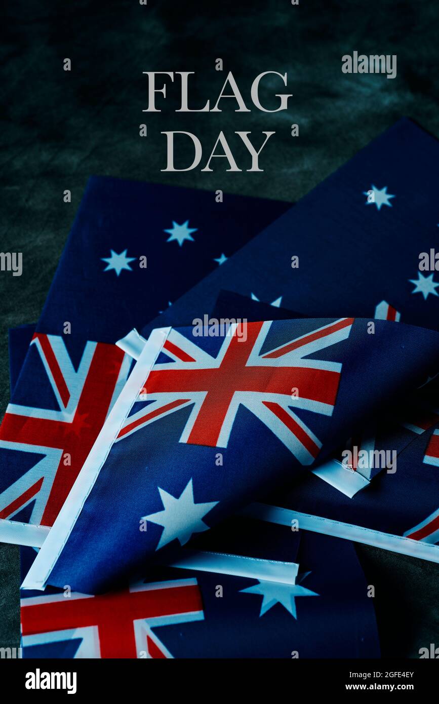 Nahaufnahme einiger australischer Flaggen und Text Happy australia Day auf dunkelgrauem Hintergrund Stockfoto