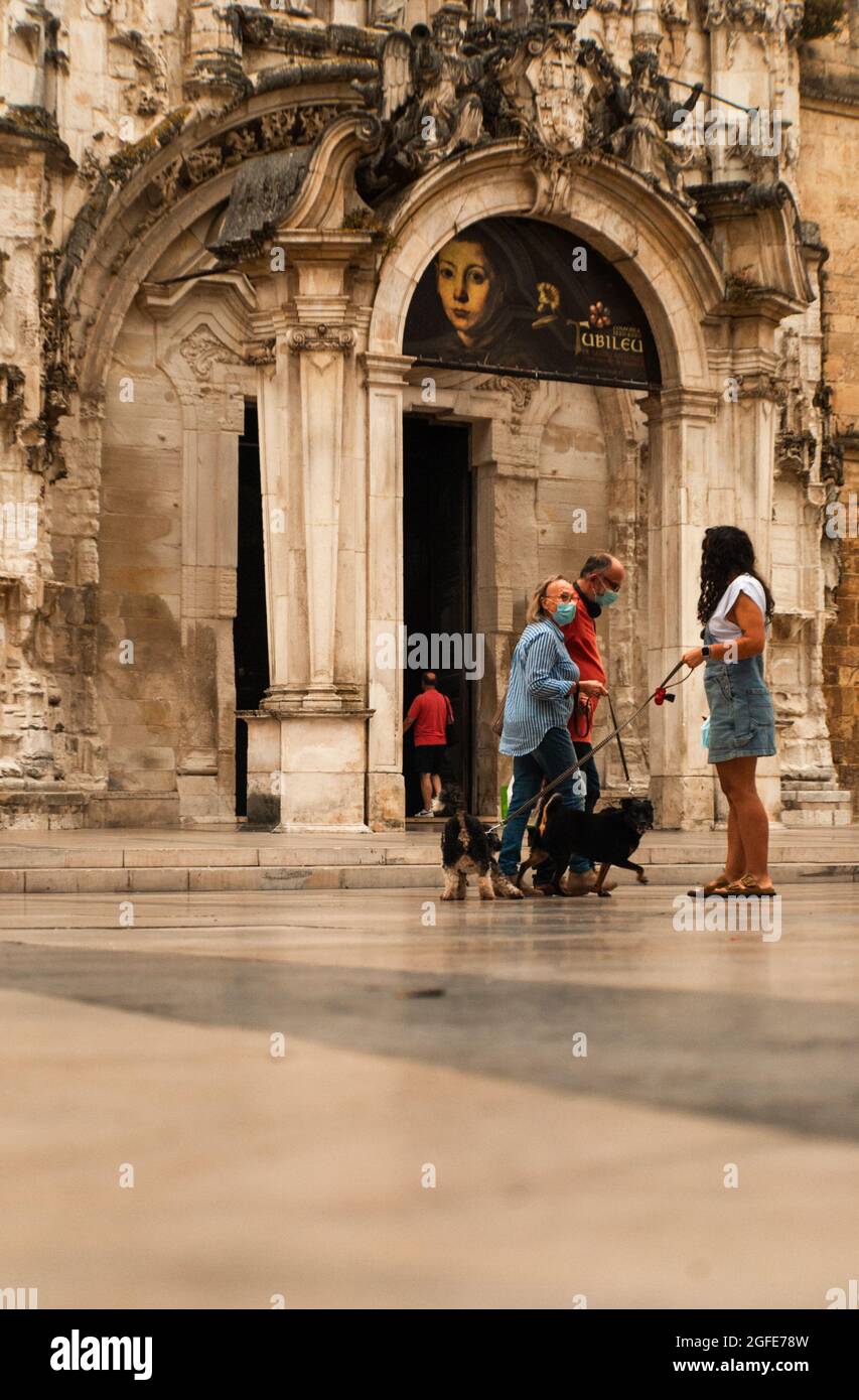 Coimbra, Portugal - 12. August 2021: Alltag von Coimbra, Menschen mit ihren Hunden auf dem Praca 8 de Maio Platz mit dem Kloster Santa Cruz im b Stockfoto
