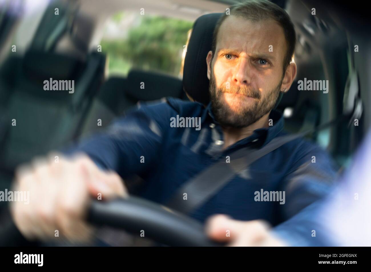 Frustrierter junger Mann, der ein Auto fährt Stockfoto