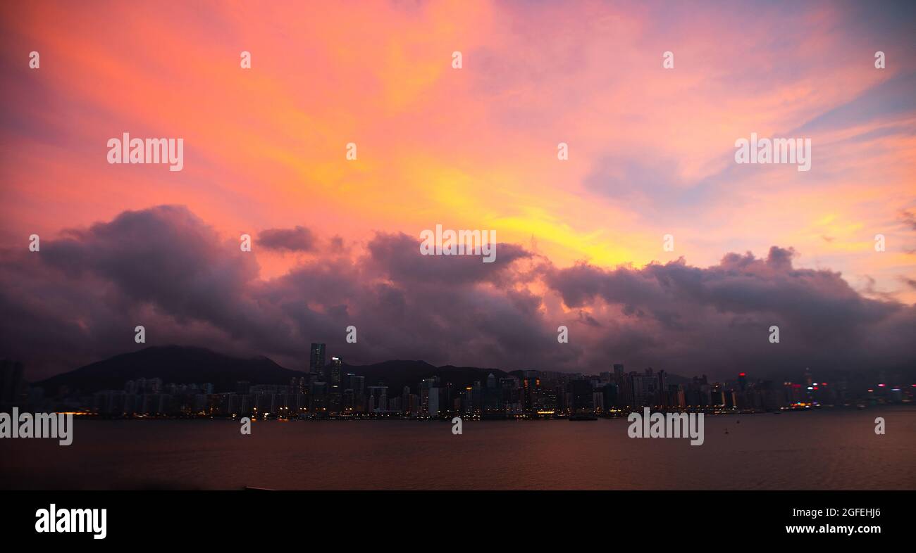 Blick auf die Skyline der Stadt unter den Sturmwolken bei Sonnenuntergang, Hongkong, China Stockfoto