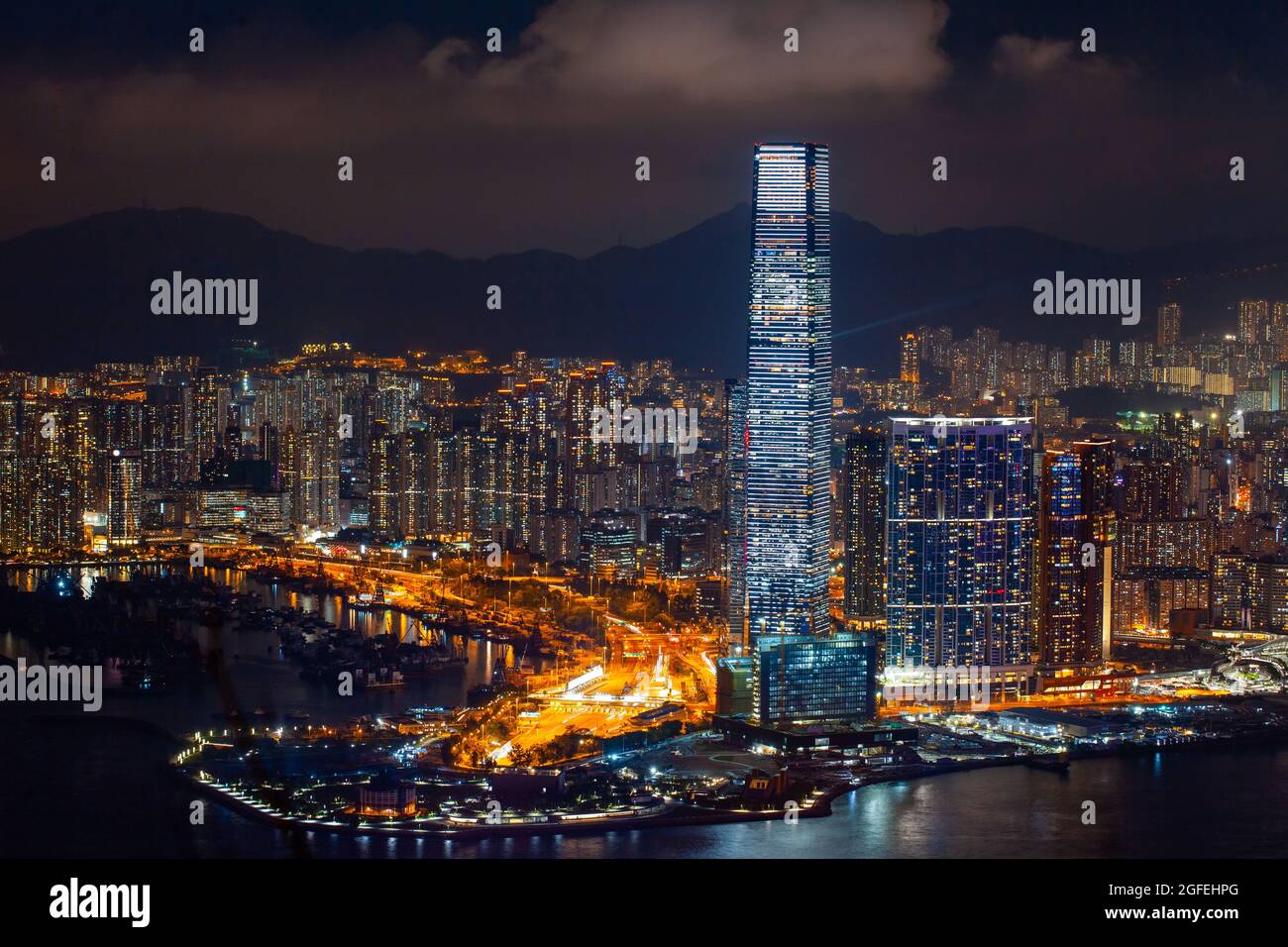 Blick auf die beleuchtete Stadtlandschaft mit Wolkenkratzern in der Nähe des Victoria Harbour in Hongkong Stockfoto