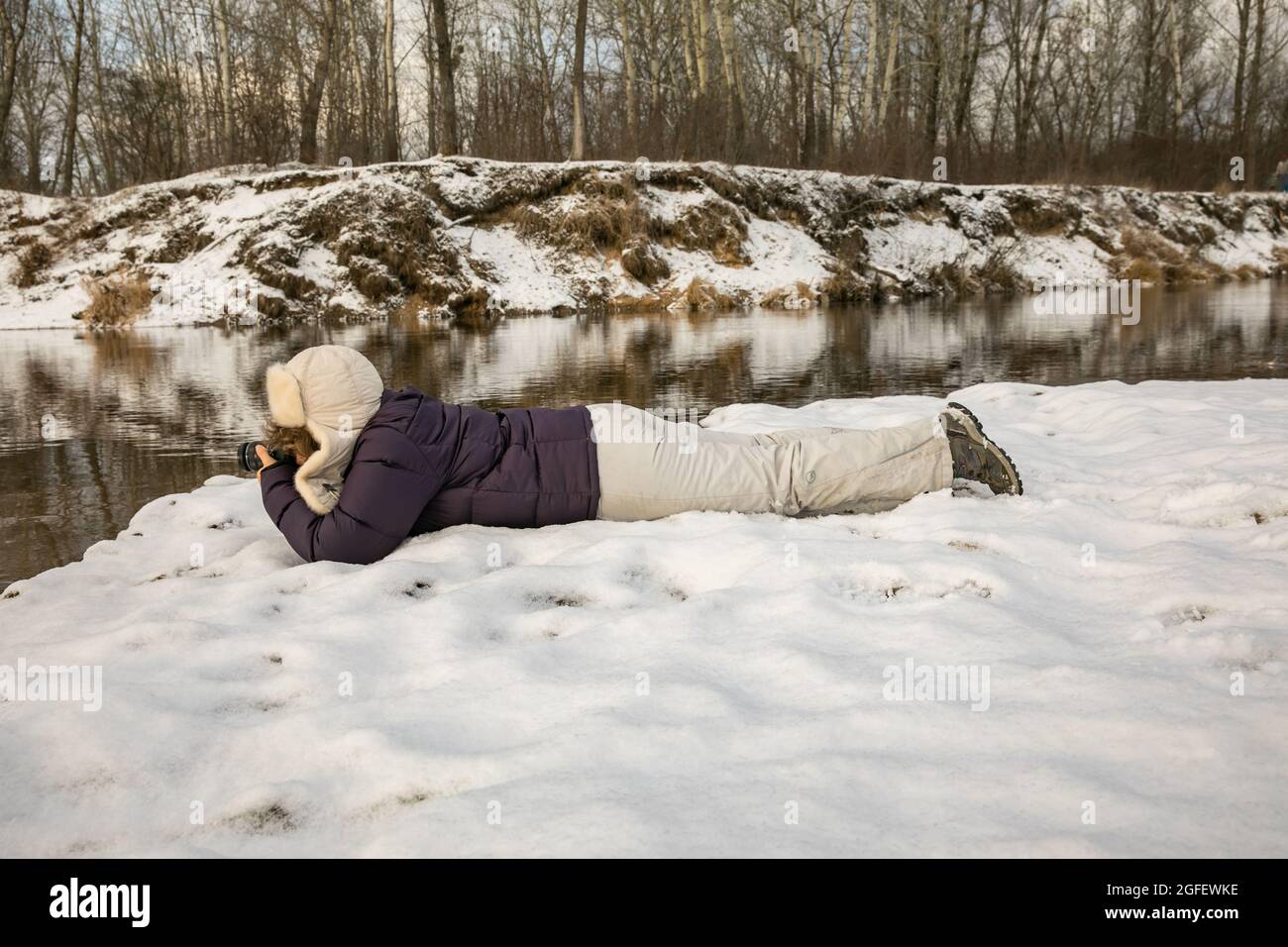 Frau, die im Winter die Bilder auf dem Ufer der Weichsel macht. Polen. Natura 2000 Stockfoto