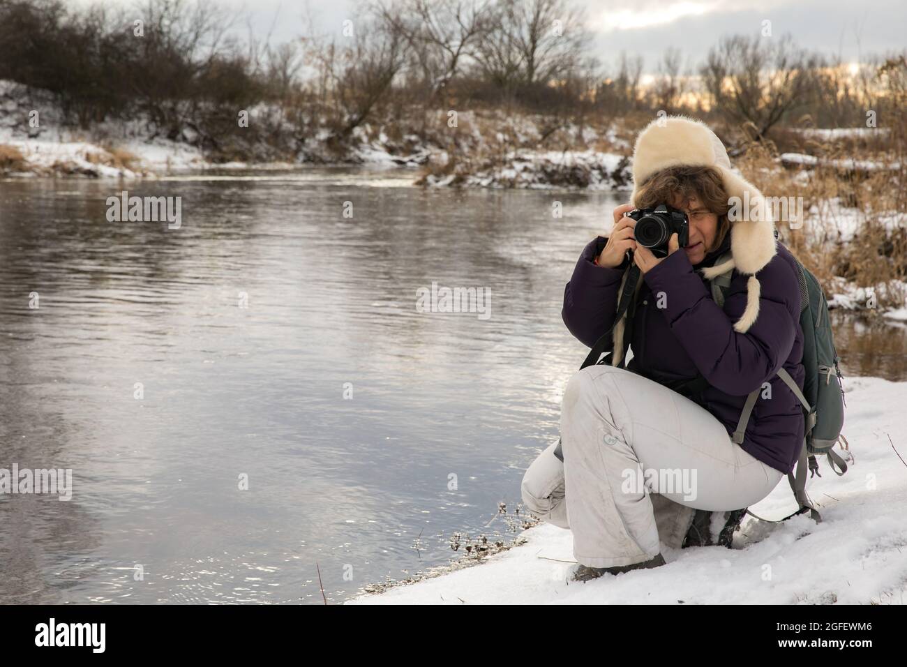 Frau, die im Winter die Bilder auf dem Ufer der Weichsel macht. Polen. Natura 2000 Stockfoto