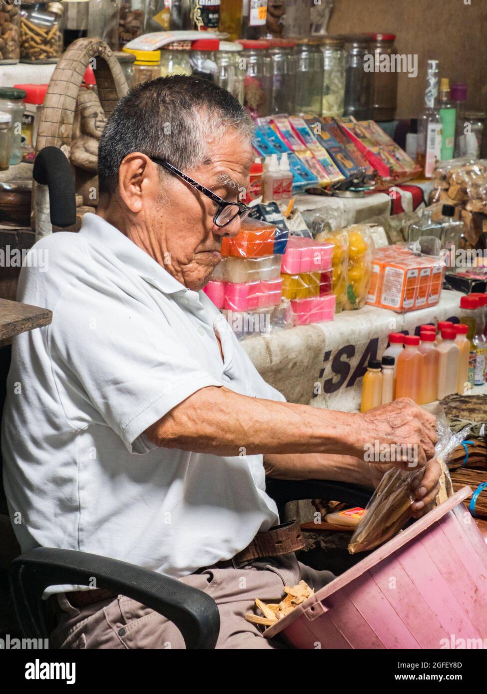 Iquitos, Peru - Dez 2019: Porträt eines alten Mannes, der auf dem Stuhl sitzt und verschiedene Dinge verkauft, die der Belen Basar (Belén Markt), Iquitos - Tor zu Stockfoto