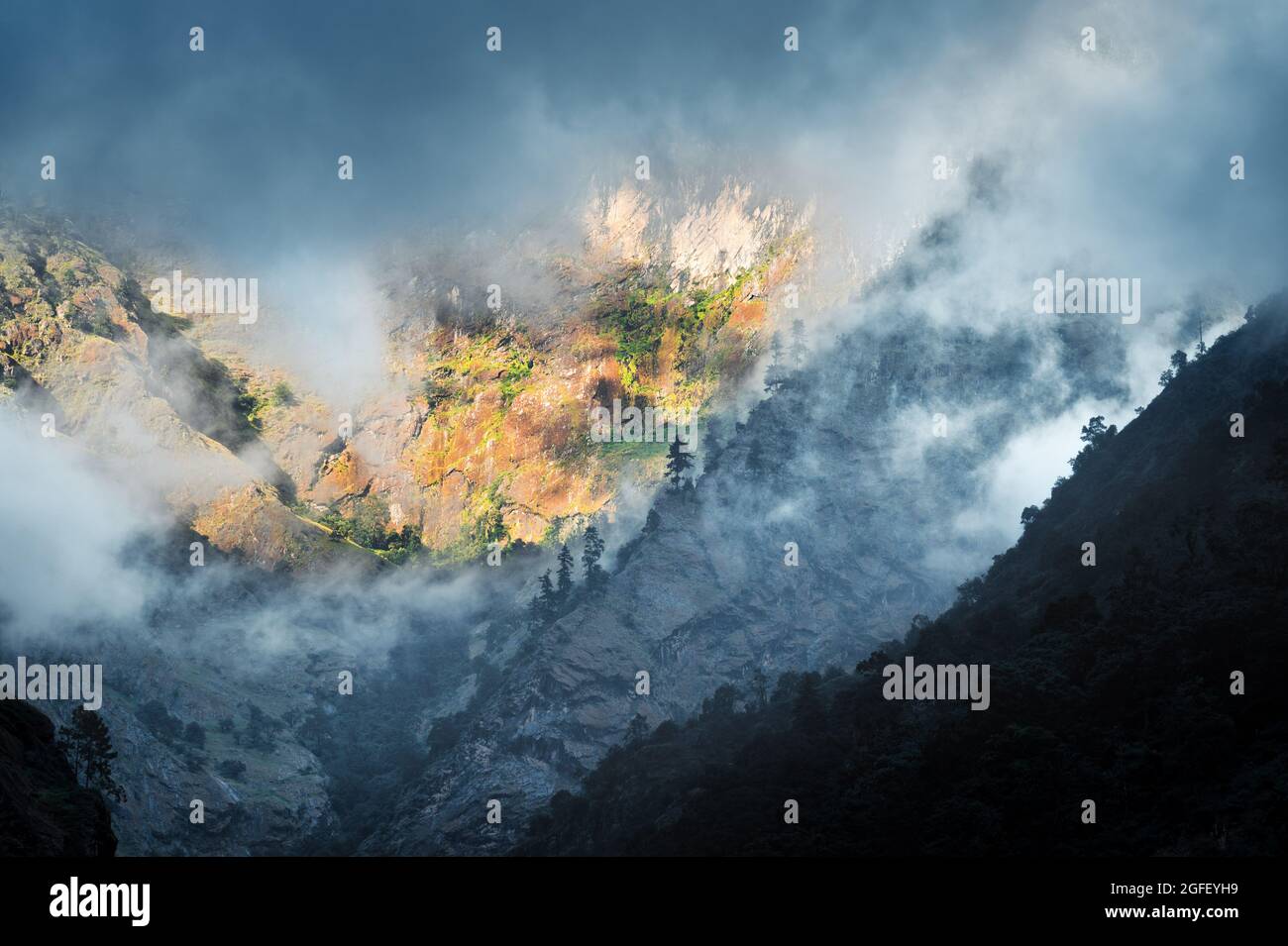 Berge in niedrigen Wolken am bewölkten Abend in Nepal Stockfoto