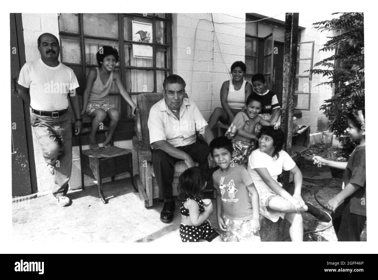 San Antonio, Texas, um 1990: Große hispanische Familie posiert vor ihrer Wohnung am Alazan-Apache Courts, dem ersten öffentlichen Wohnhaus von San Antonio, das 1939 erbaut wurde. Anfang der 1990er Jahre litt das Projekt unter schwerer Überfüllung. Original in Farbe ©Bob Daemmrich Stockfoto