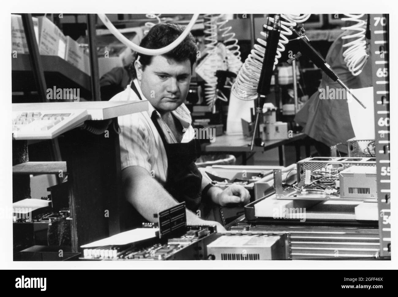 Austin Texas USA, um 1993: Männlicher Mitarbeiter an der Produktionslinie, der Dell Computer-Produkte aus verschiedenen Komponenten zusammenstellt. Original in Farbe ©Bob Daemmrich Stockfoto