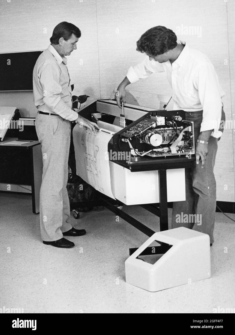 Austin Texas USA, um 1992: Reparaturtechniker arbeiten in einem Architekturbüro an Computerentwurfgeräten. ©Bob Daemmrich Stockfoto