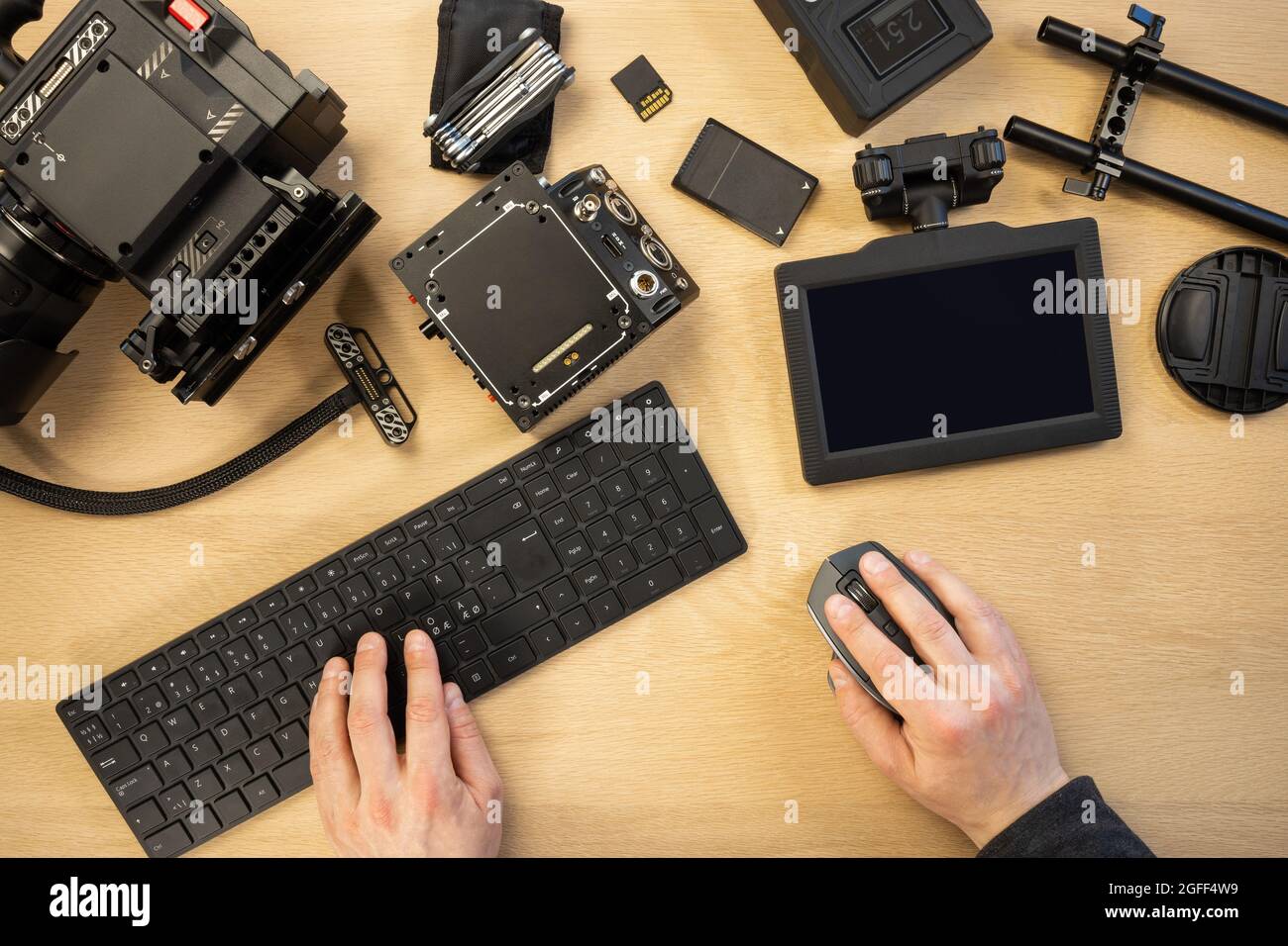Kreativer Fotograf, der Computerteile nach Geräten am Tisch verwendet Stockfoto
