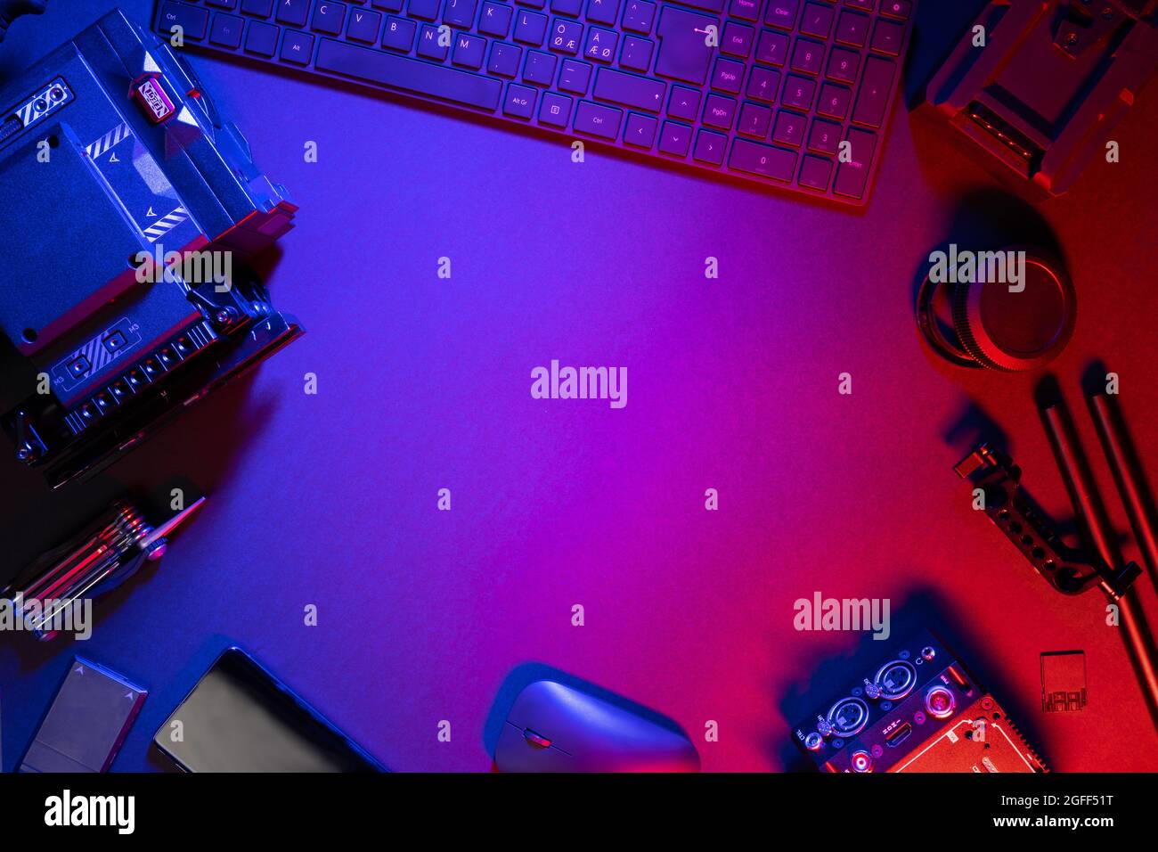 Flache Verlegung von Computerteilen und Videokamera auf beleuchtetem Tisch Stockfoto