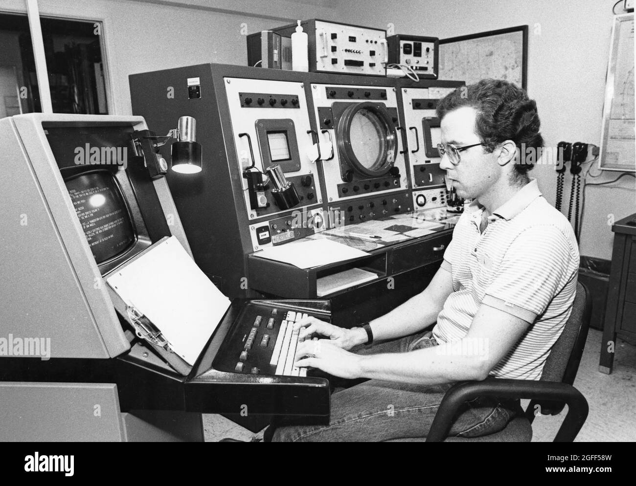 Austin Texas USA, um 1991: Der Meteorologe des National Weather Service, umgeben von Wetterdaten, arbeitet an seinem Computerterminal. ©Bob Daemmrich Stockfoto