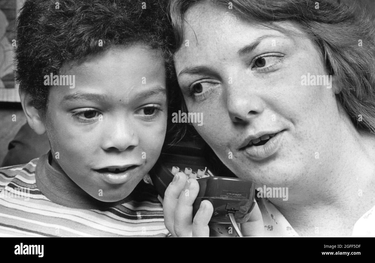 Austin Texas USA, um 1984: Mutter und Adoptivkind hören sich die Space Shuttle-Gespräche am Telefon an. ©Bob Daemmrich Stockfoto