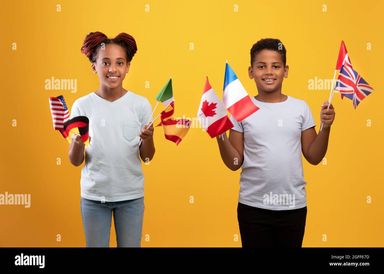 Glückliche schwarze Kinder posieren mit verschiedenen Fahnen Stockfoto