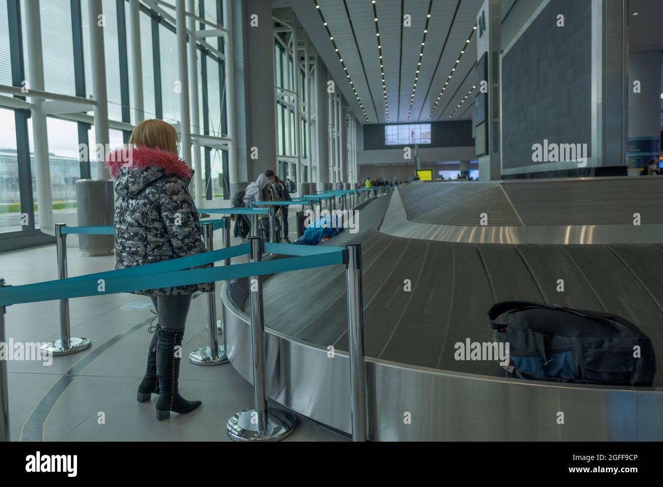 Arnavutkoy, Istanbul, Türkei - 03.11.2021: Gepäckkarussell am Flughafen Istanbul und Passagiere mit Maske warten auf ihr Gepäck und ihre Taschen um den Reclai herum Stockfoto