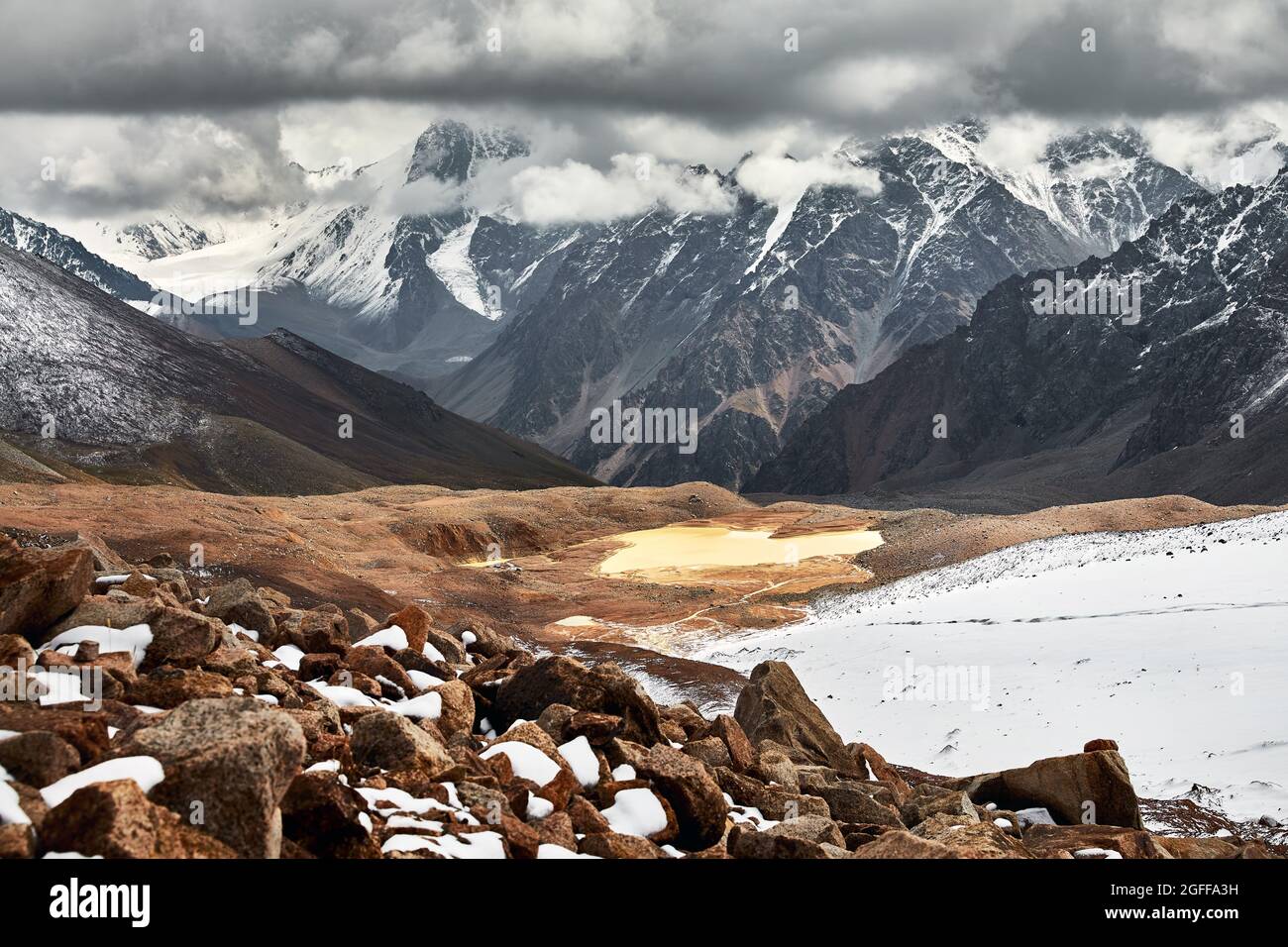 Wunderschöne Landschaft des Gletschers und des schneebedeckten Bergsees am wolkenbedeckten Himmel in Tien Shan, Kasachstan. Stockfoto