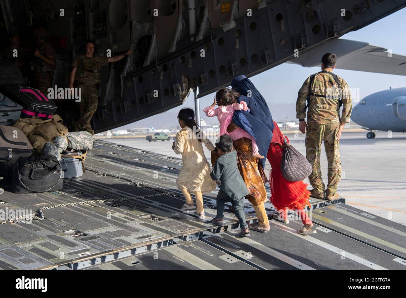 Kabul, Afghanistan. August 2021. Afghanische Flüchtlinge besteigen ein C-17 Globemaster III-Flugzeug zur Evakuierung vom Hamid Karzai International Airport während der Operation Allies Refuge am 24. August 2021 in Kabul, Afghanistan. Quelle: Planetpix/Alamy Live News Stockfoto