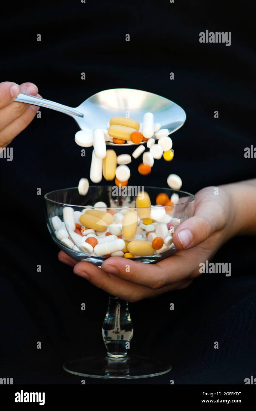 Einnahme von Medikamenten mit einem Esslöffel aus einem Glas Stockfoto