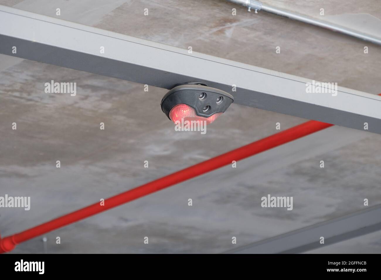Das rote Licht der elektronischen Lampe zur Anzeige des nicht verfügbaren Steckplatzes im Parkhaus des Einkaufszentrums, Vorderansicht mit dem c Stockfoto